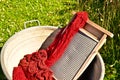 An old fashioned washing trougth filled with dyed and washed strings and ropes of red wool