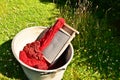 An old fashioned washing trougth filled with dyed and washed strings and ropes of red wool