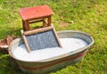 An old fashioned washing trougth a vintage child chair, and wooden vessels to bring water Royalty Free Stock Photo