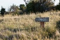 Old-fashioned weathered sign for track in a field