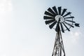 Old-fashioned wind pump against pale blue sky Royalty Free Stock Photo