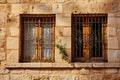 Old fashioned wooden window with bars on stone wall