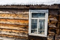 Old- fashioned wooden window in winter, roof of the house covered with snow