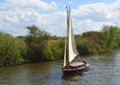 Old Fashioned Yacht under sail navigating the river Bure near Horning, the Norfolk Broads. Royalty Free Stock Photo