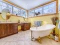 Old-fashioned yellow bathroom with wooden cabinets