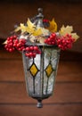 Vintage handmade lantern with painting and garland of maple leaves and rowen berries