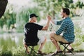 Old Father with Bearded Son Fishing on River. Royalty Free Stock Photo