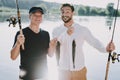 Old Father with Bearded Son Fishing on River. Royalty Free Stock Photo