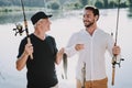 Old Father with Bearded Son Fishing on River. Royalty Free Stock Photo