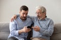 Old father and son using phone, shocked by unexpected news Royalty Free Stock Photo