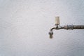 Old faucet for the outside with a white facade in the background Royalty Free Stock Photo