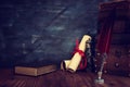 Old feather quill ink pen with inkwell and old books over wooden desk in front of black wall background. Conceptual photo on Royalty Free Stock Photo