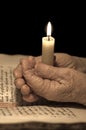 Old female hands with a candle