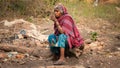 Old female Indian beggar having tea.