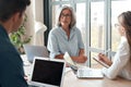 Old female mentor supervisor training young interns at group office meeting. Royalty Free Stock Photo