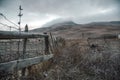 Old fence in a field at dawn. Dawn in autumn field. Hills in morning haze. Grass covered with autumn hoarfrost. Nature in Royalty Free Stock Photo