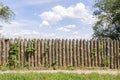 Old fence of logs. Palisade against the blue sky Royalty Free Stock Photo