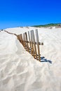 Old fence sticking out of deserted sandy beach dunes Royalty Free Stock Photo