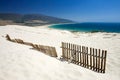 Old fence sticking out of deserted sandy beach dunes Royalty Free Stock Photo