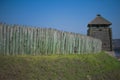 old fence of a stockade and watchtower against a blue sky background