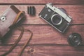 Old film camera with lens, case and film on wooden background. Vintage toned and top view Royalty Free Stock Photo