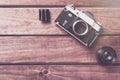 Old film camera with lens and film on wooden background. Vintage toned and top view Royalty Free Stock Photo