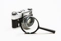 Old film camera and magnifying glass. White background close-up. Vintage photo Royalty Free Stock Photo