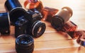 Old film camera and a roll of on wood Royalty Free Stock Photo