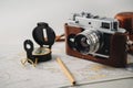 Old film photo camera, magnetic compass and pencil lying on map Royalty Free Stock Photo