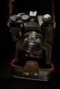 An old film rangefinder SLR camera in a shabby case on a dark background Royalty Free Stock Photo