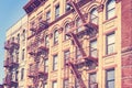 Old film retro toned photo of New York building with fire escape