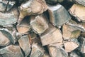 Old Firewood or fuelwood stacked by a wall. Texture woodpile