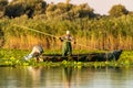 Old fisherman gathering nets in Danube Delta Romania. Traditional fishing .