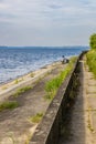 Old fisherman in hat and dark glasses do fishing at the coast of big lake Royalty Free Stock Photo