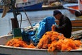 The old fisherman is preparing the fishing net on his boat to go fishing Royalty Free Stock Photo