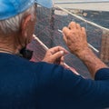 Old fisherman repairs fishing net