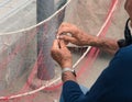 Senior fisherman reparing fishing net