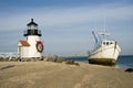 Old fishing boat aground next to a lighthouse at Christmas time