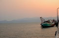 old fishing boat broken stop on harbor bridge in sunset. beauty twilight golden light and fog over the sea and island Royalty Free Stock Photo