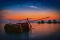 The old fishing boat capsized on sea with milky way at sunset in Royalty Free Stock Photo