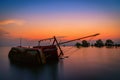 The old fishing boat capsized on sea at sunset in Phuket Royalty Free Stock Photo