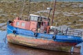 Old fishing boat in Clifden Bay at low tide