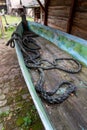 An old fishing boat with a mooring rope at the bottom. A thick rope at the bottom of the boat Royalty Free Stock Photo