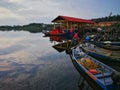 Old fishing boat near wooden jetty. Beautiful malaysian landscape. Sunset reflection in the water. Royalty Free Stock Photo