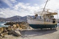 Old fishing boat on the shore. A ship pulled ashore. Harbor in the village of Hersonissos on the island of Crete, Greece. Royalty Free Stock Photo