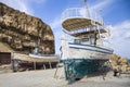 Old fishing boat on the shore. A ship pulled ashore. Harbor in the village of Hersonissos on the island of Crete, Greece. Royalty Free Stock Photo