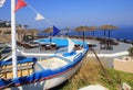 old fishing boat, sun beds and pool on terrace over Mediterranean sea, Santorini