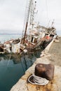 An old fishing boat sunk at a pier in seaport Royalty Free Stock Photo