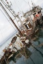 An old fishing boat sunk at a pier in seaport Royalty Free Stock Photo