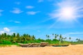 Old fishing boats on a sandy beach against the backdrop of palm trees and the sky Royalty Free Stock Photo